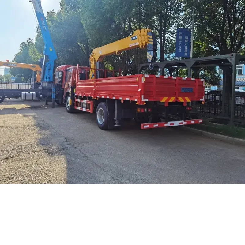 Rear three-quarter view of the red Howman crane truck with the drop-side cargo body and the stowed knuckle-boom crane