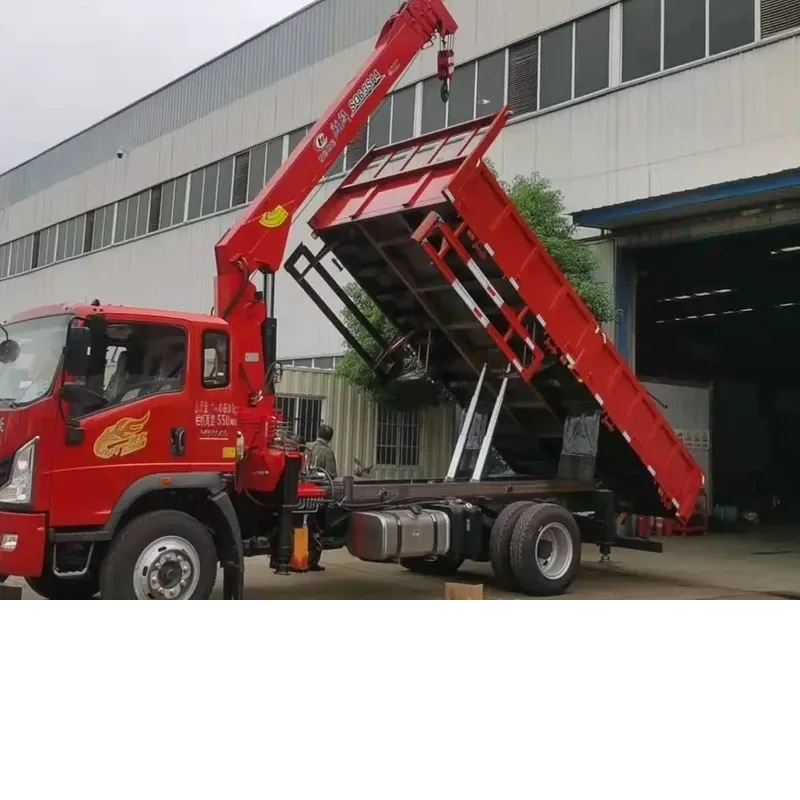 Howman crane truck with the cargo body raised in the tipping position and the crane boom extended, in front of the factory