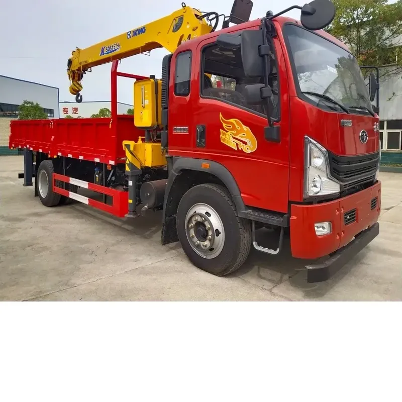 Red Howman crane truck in a factory yard, three-quarter front-left view with the knuckle-boom crane folded over the cargo body