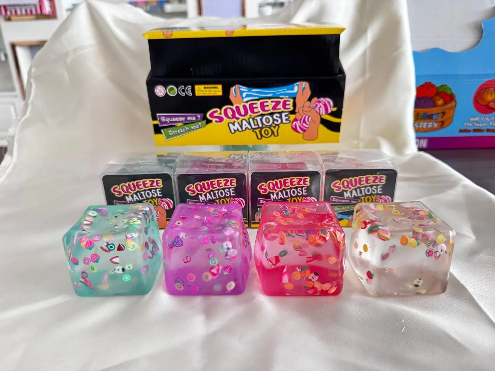Clear squishy cubes with fruit-style decorative details and display packaging