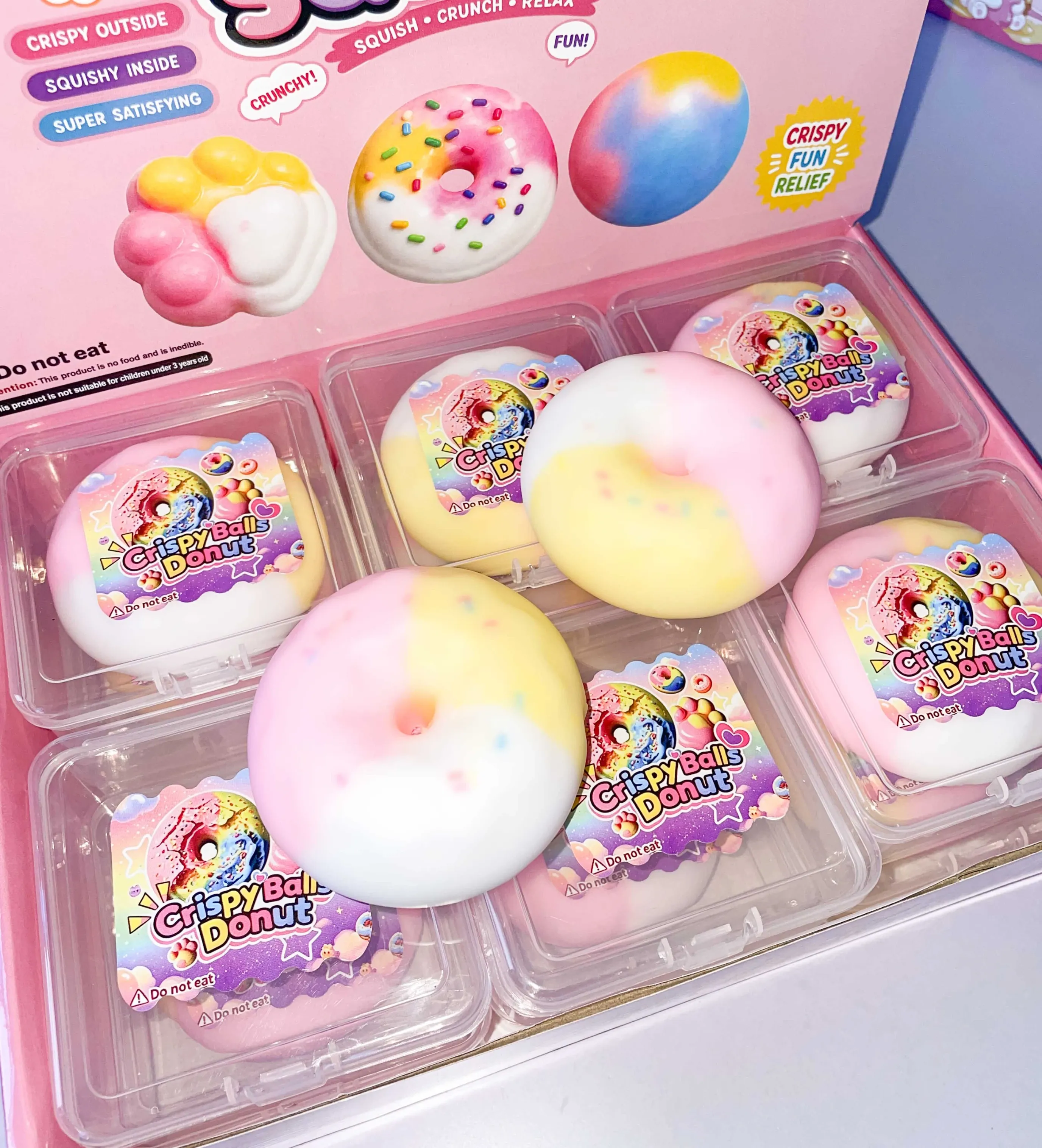 Donut-shaped squishy toys in assorted colours with display packaging