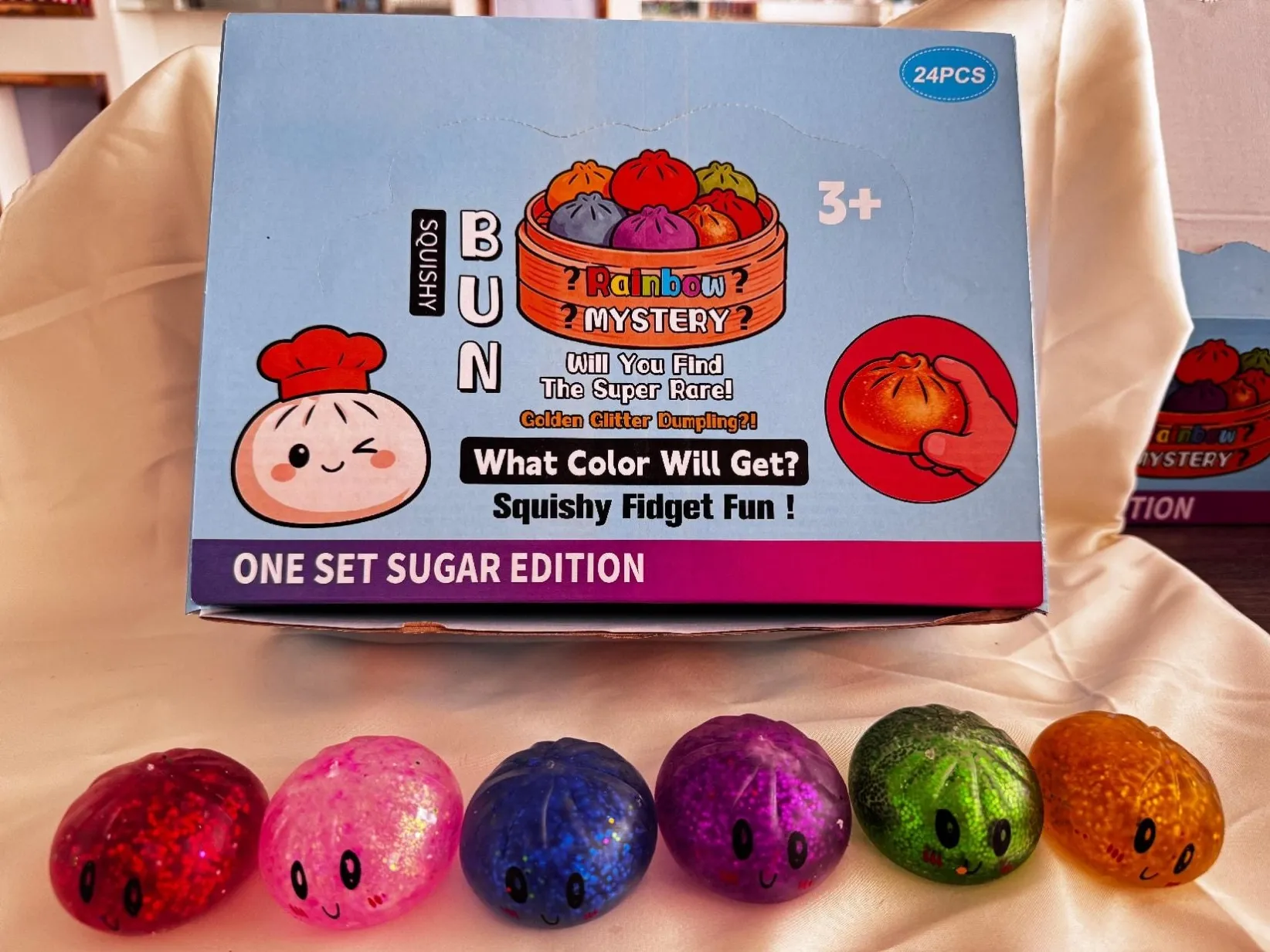 Small colourful dumpling-shaped squishy toys in front of display packaging