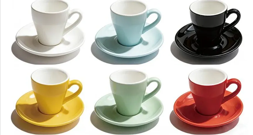 Six ceramic espresso cups with matching saucers in white, pale blue, black, yellow, mint and red.