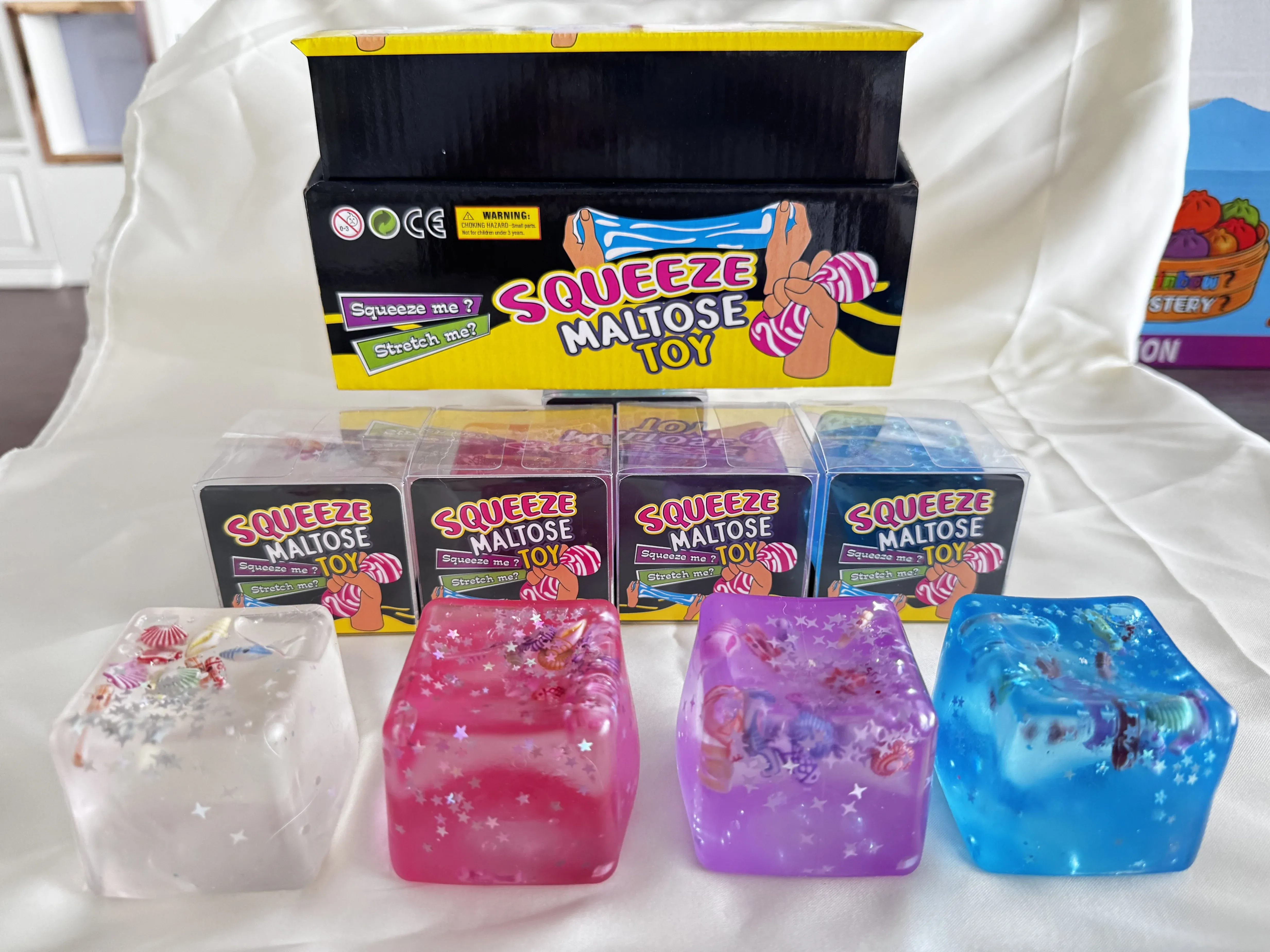 Colourful clear squishy cubes with decorative details and display packaging