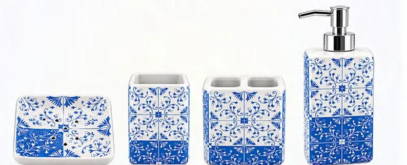 Four square ceramic bathroom accessories with blue-and-white patterns: a soap dish, tumbler, toothbrush holder and dispenser.