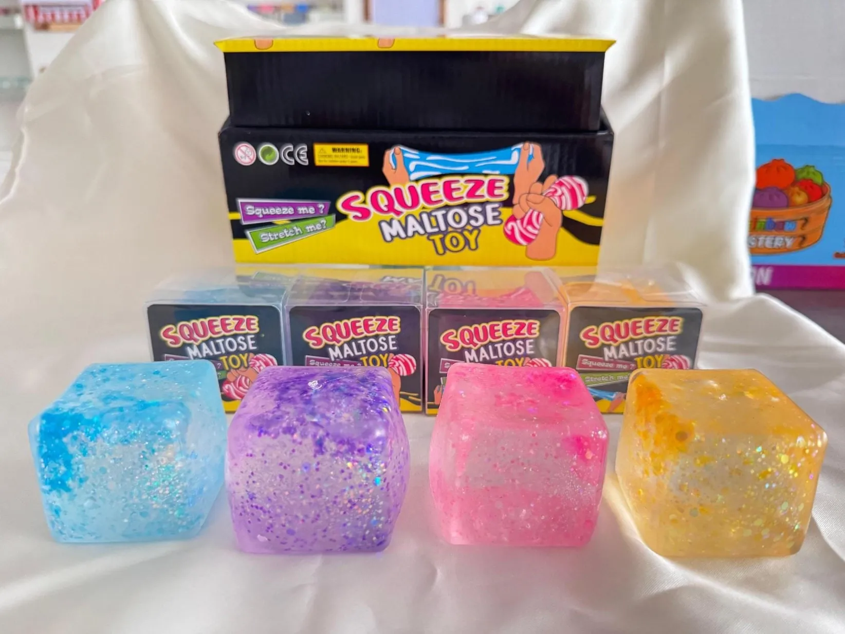 Colourful glitter-look squishy cubes with display packaging