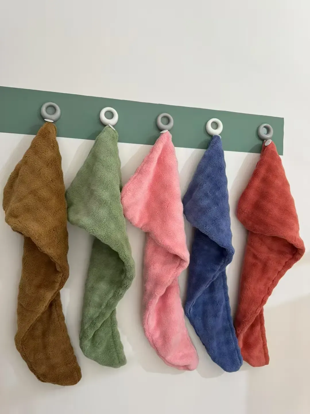 Bubble-textured hair towel wraps in assorted colors displayed on hooks