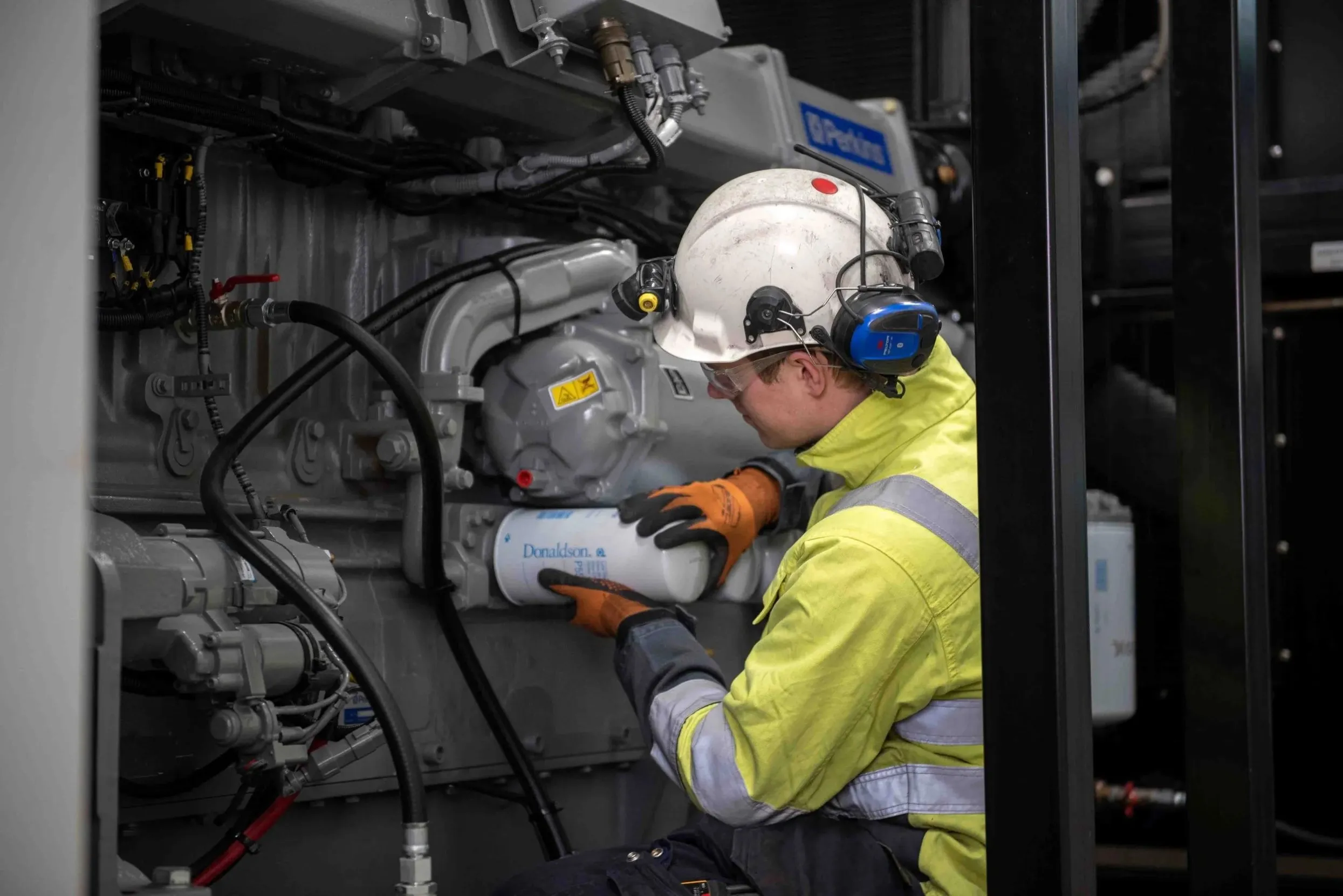 echnician maintaining filters for a heavy-duty diesel generator