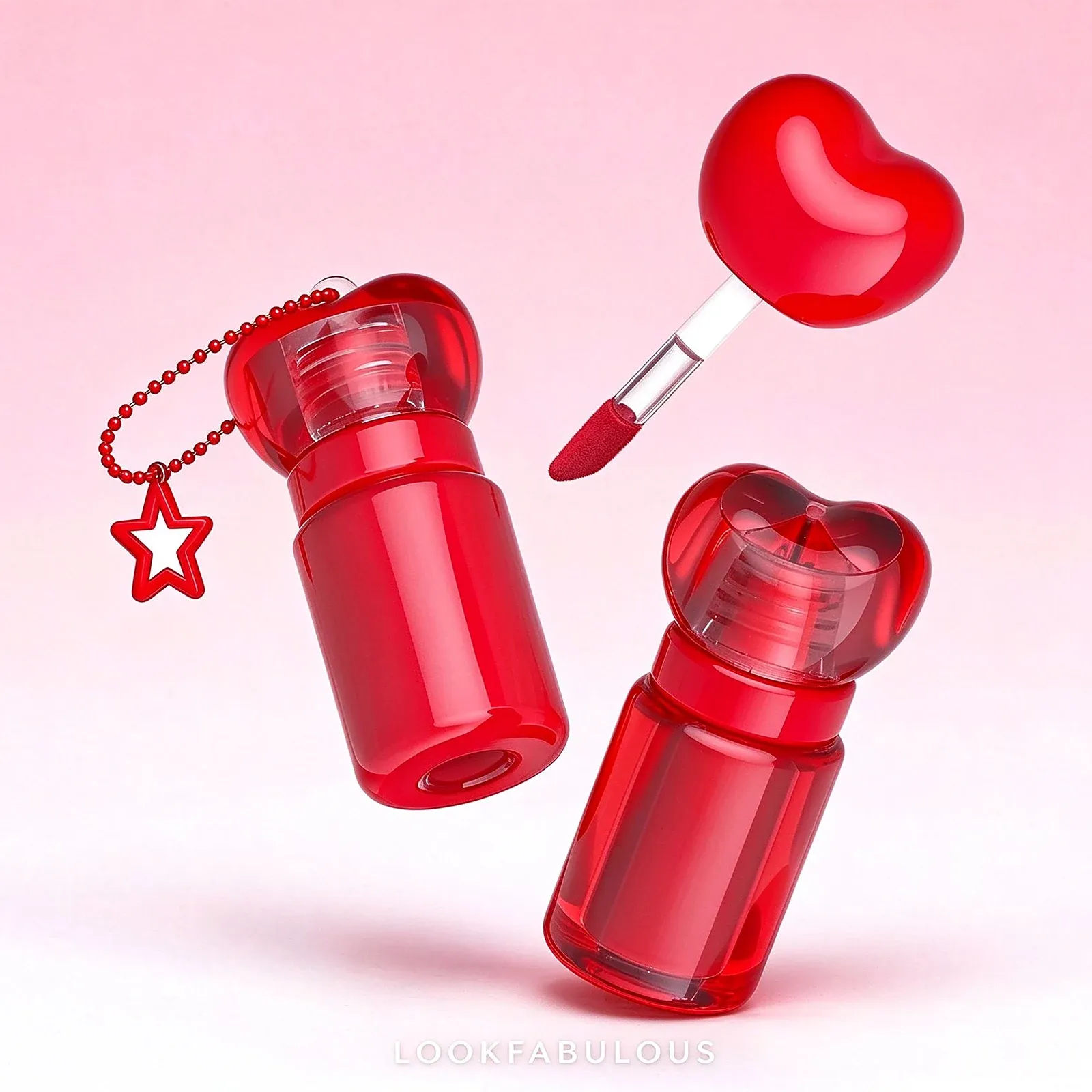 Two red lip gloss tubes with heart-shaped caps, a heart wand and a chain with a red star charm