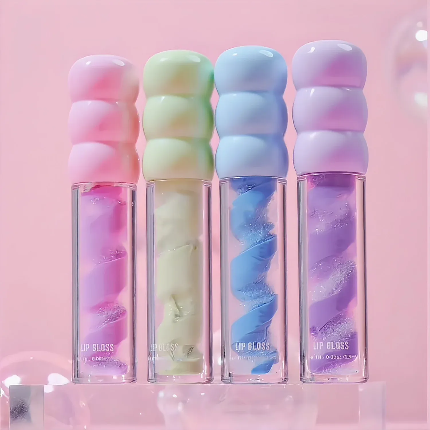 Four lip gloss tubes with soft twist bodies and marshmallow caps in pastel pink, yellow, blue and lilac