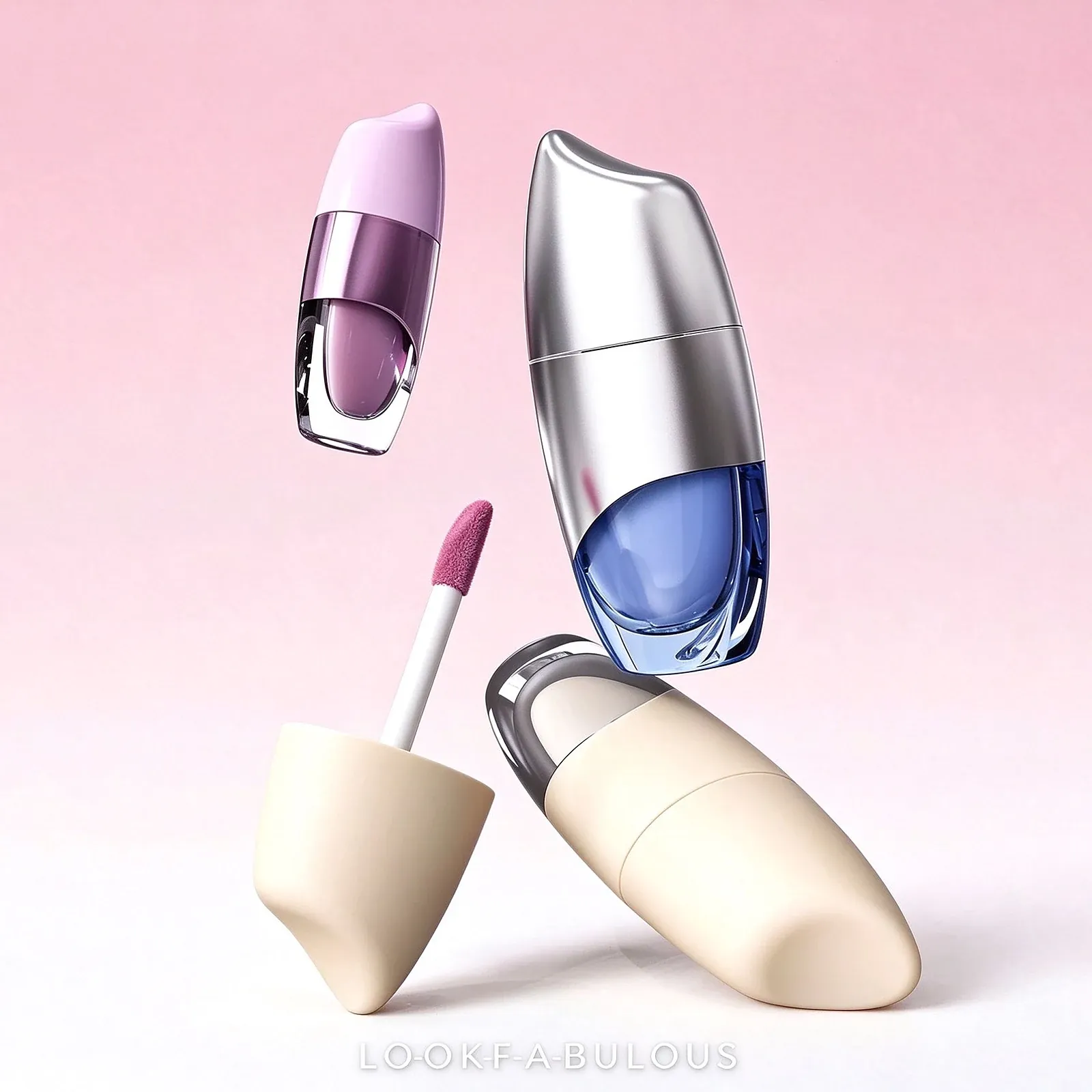 Three drop shaped lip glaze tubes with a metallic silver shell, a lilac shell and a cream shell, each with a clear window and coloured gloss