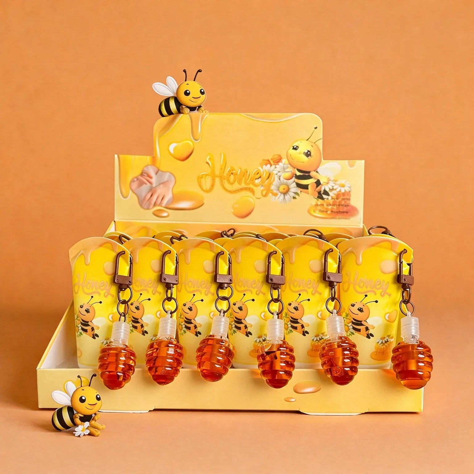 Honey hand cream tubes with amber honey-drop charms and bee design in a yellow display box