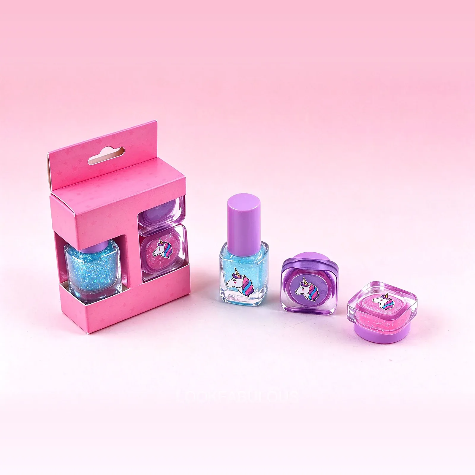 Plain pink carry box open beside a blue square polish and two rounded square unicorn pots