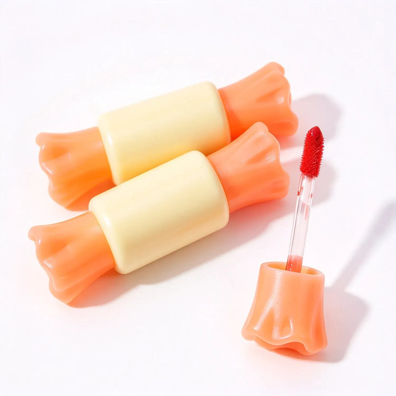 Ice pop shaped lip gloss bars in orange and cream with a brush