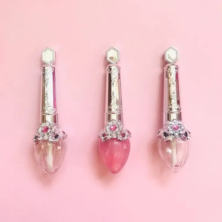 Jewelry-style lip gloss wands with golden caps and heart-shaped gloss tips