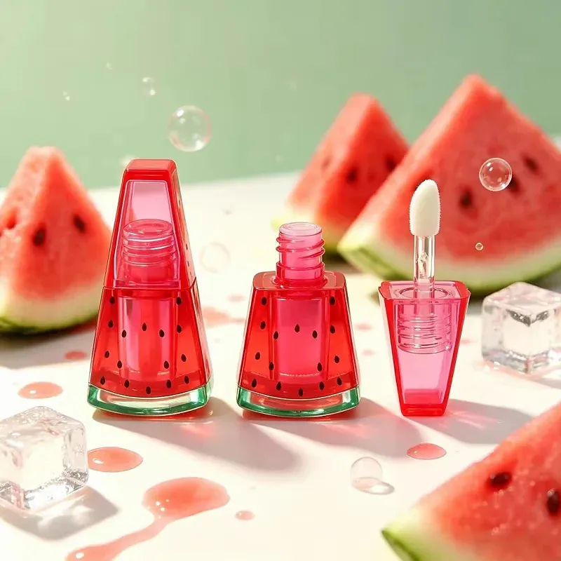 Watermelon lip gloss bottles with a lip brush applicator arranged on a melon slice