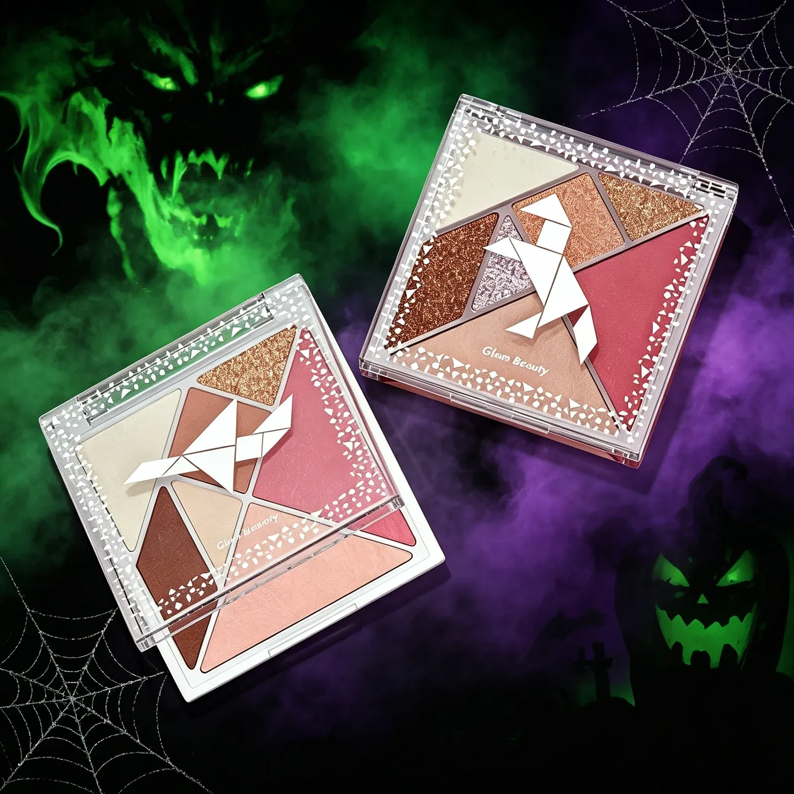 Origami Bird Eyeshadow Palette - Two square six-pan palettes with clear lids edged in white triangles, holding cream, gold, copper, white, pink and burgundy shades, shown with a folded white paper bird.
