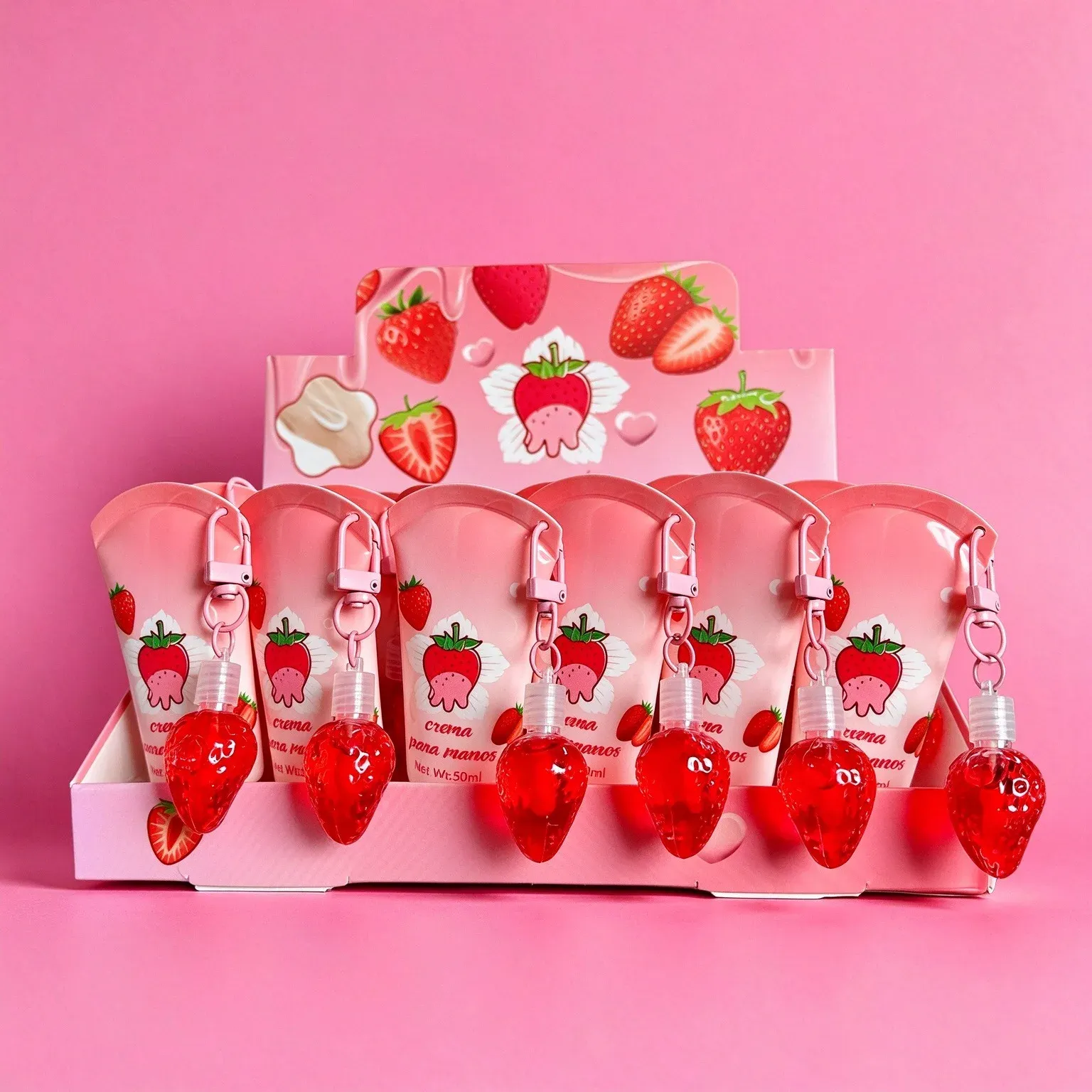 Strawberry hand cream tubes with red strawberry charms and clips in a pink display box