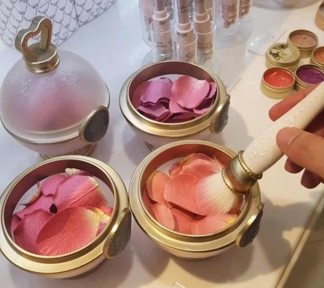 Rose petal blush pieces in round gold compact with brush