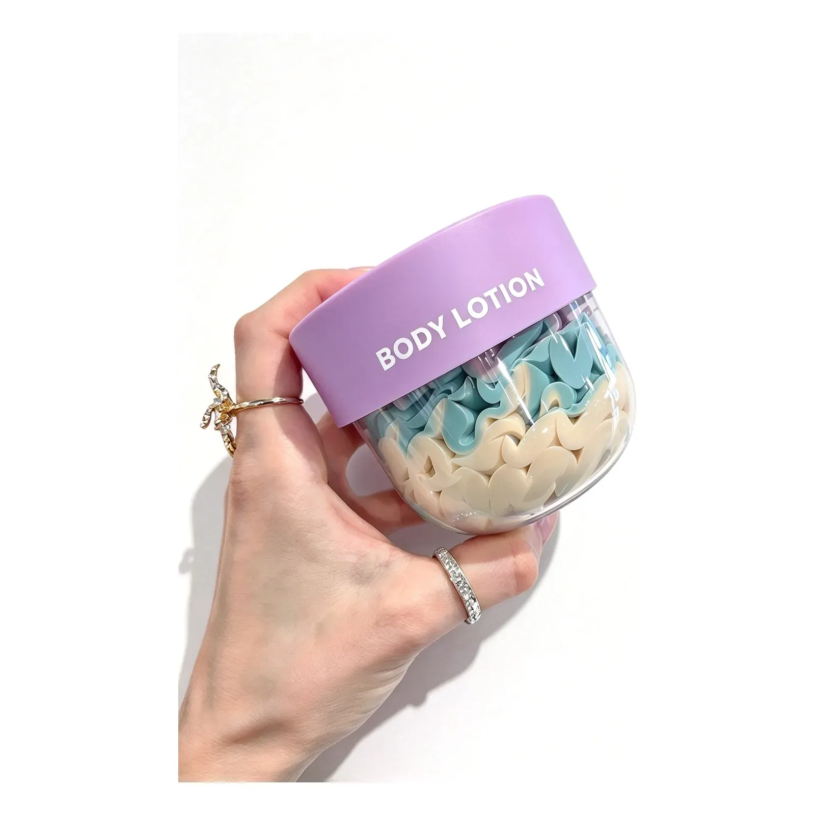 Two-tone whipped body lotion in a clear jar with lilac lid, blue and cream swirl