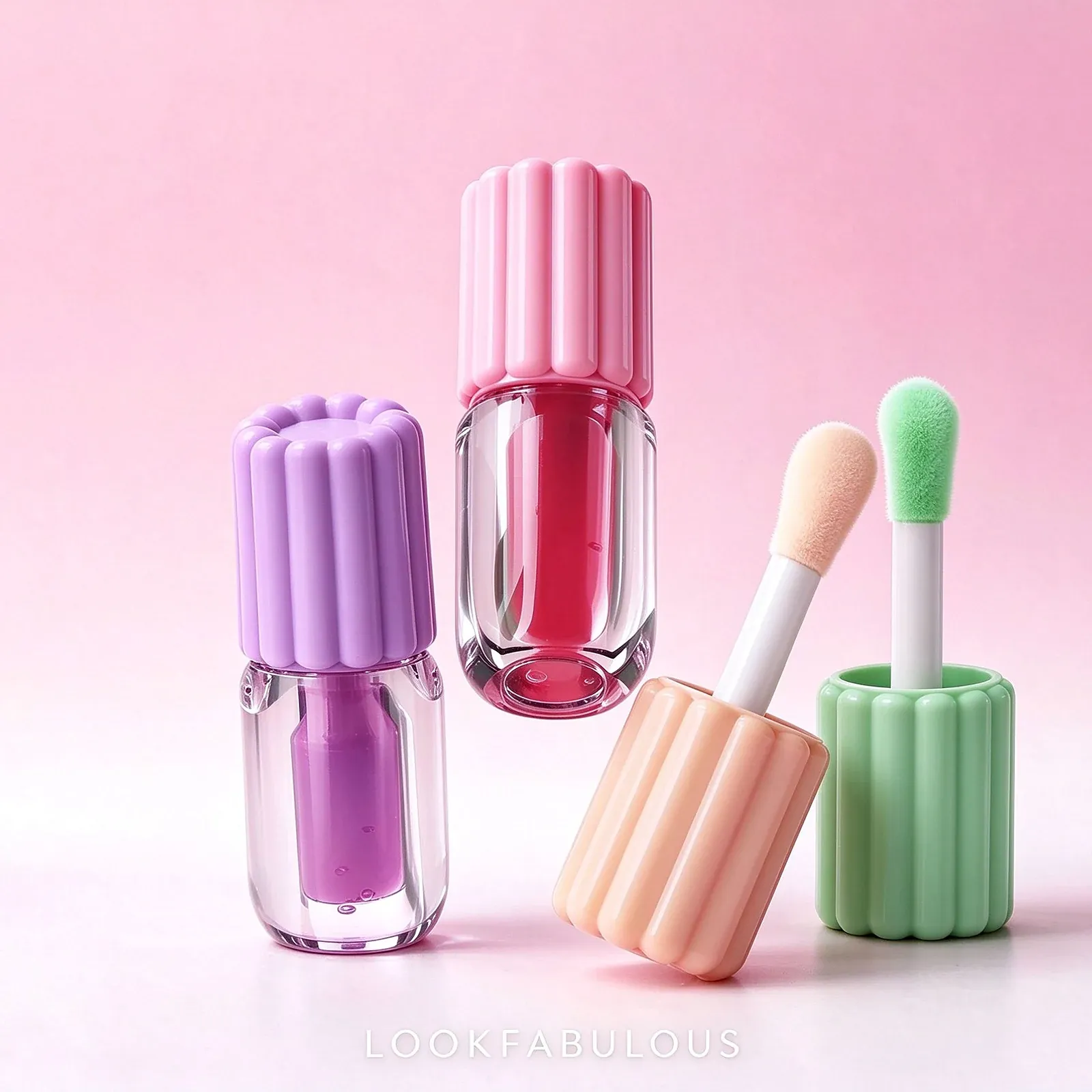 Square clear lip oil bottles with pastel ribbed caps and oversized sponge wands