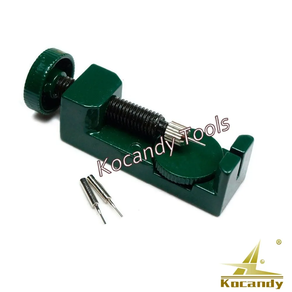 Green watch pin remover tipped at an angle with a spare pin