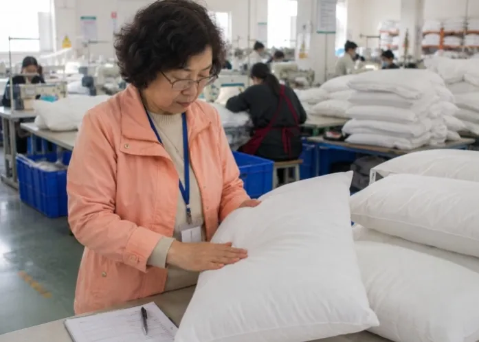Experienced third-party inspector reviewing household goods during production in a China factory with finished cartons in the background
