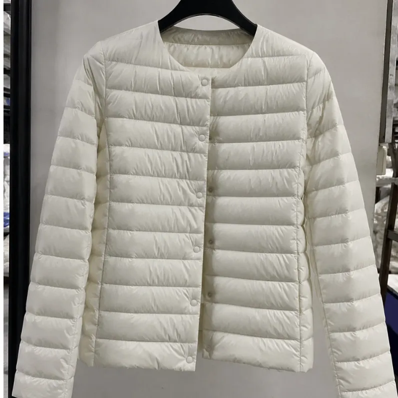 Fine down fibers visible on dark ultra-light down jacket fabric during inspection