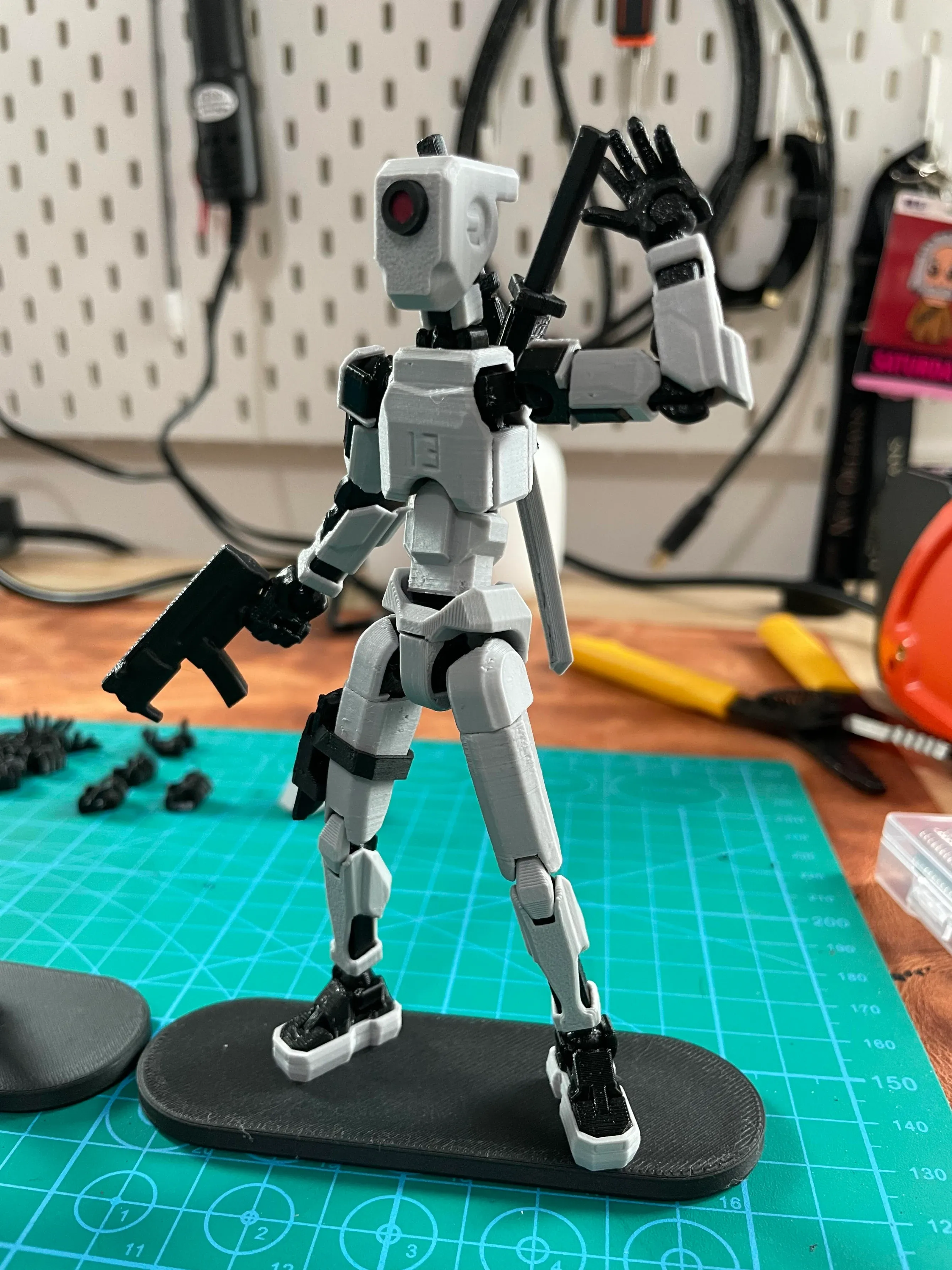 External reference by IndustrialJones: a gray 3D-printed articulated figure with magnetic boots on a black display board