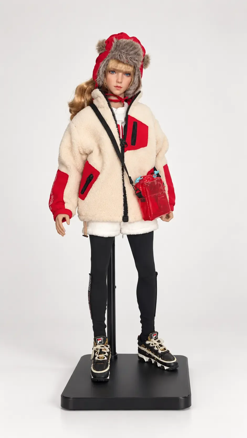 Collectible figure in a cream-and-red fabric coat and fur-trimmed hat, with a red shoulder bag, on a black display stand
