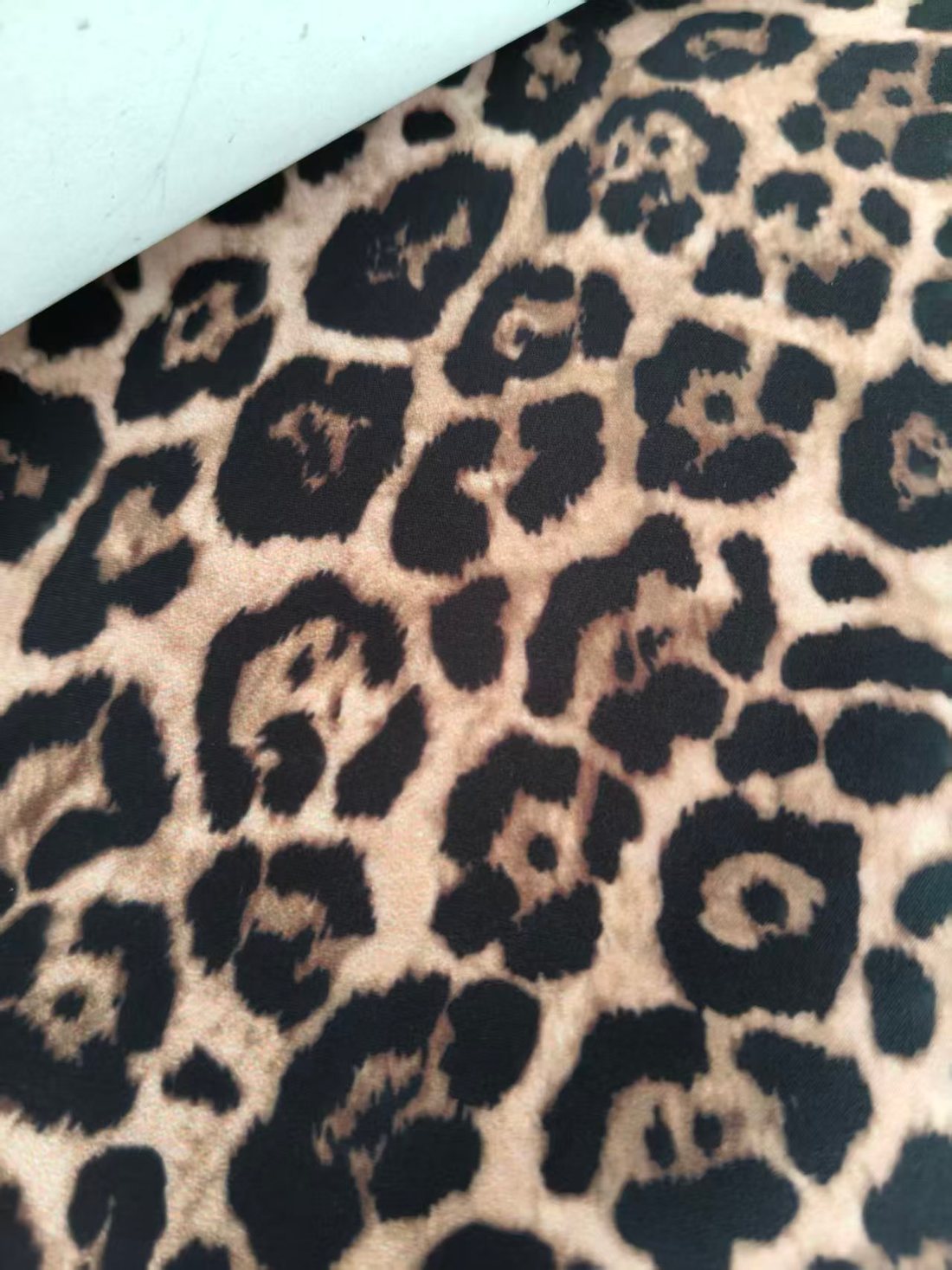 Leopard print fabric roll showing print quality on white base