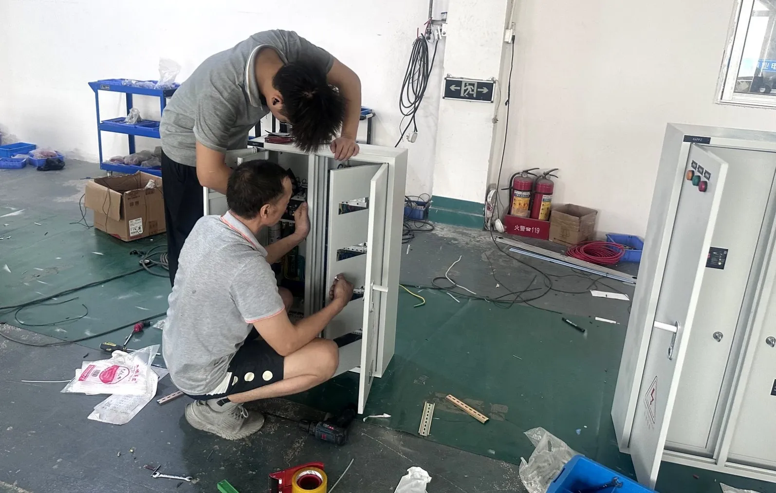 Technicians assembling a control panel to drawing