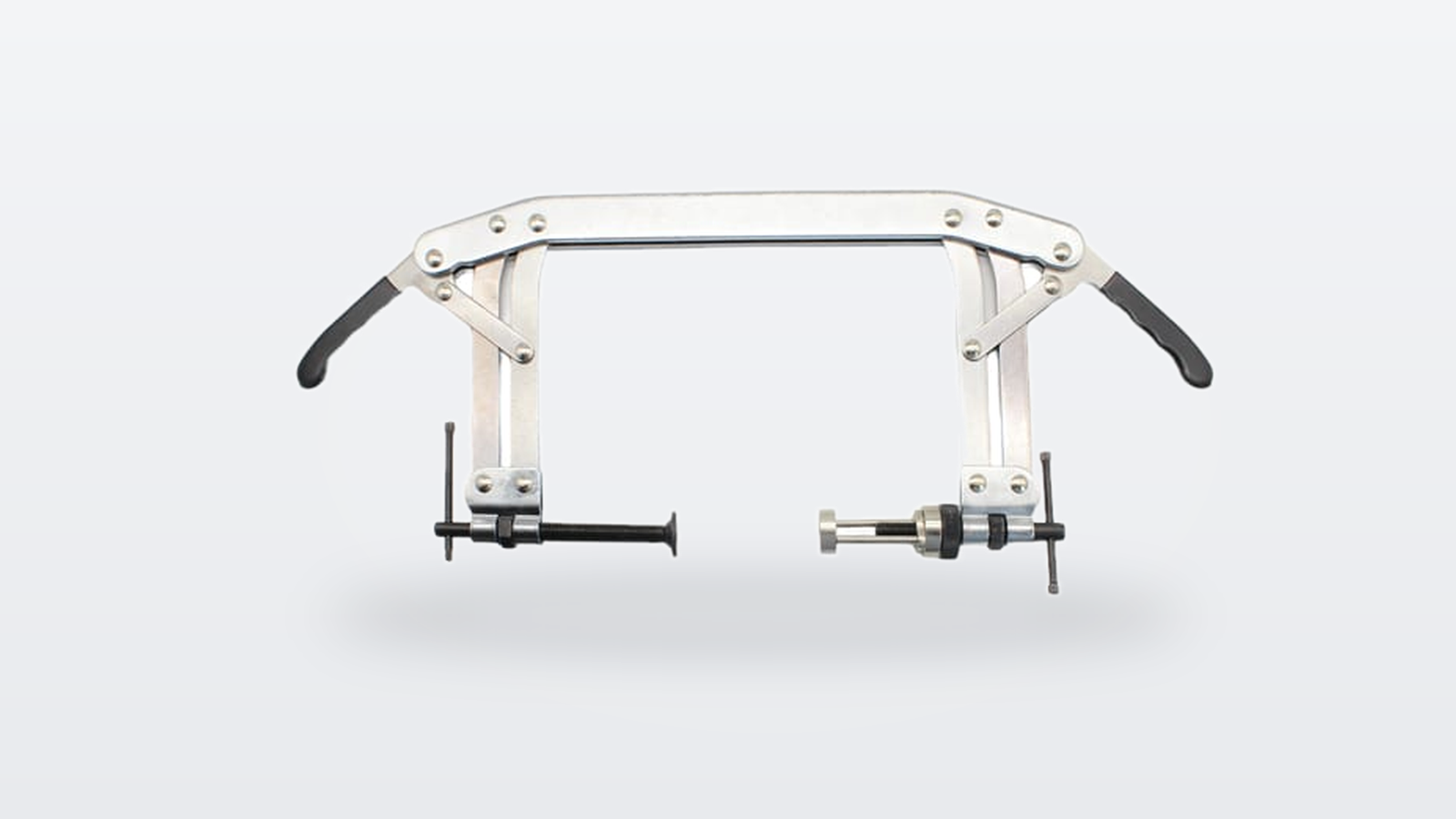 Multi valve spring compressor: the bridge-type compressor with black grips and T-handles on a light grey background