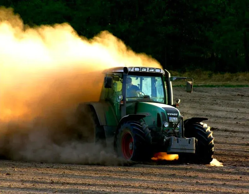 tractor raising dust during agricultural fieldwork