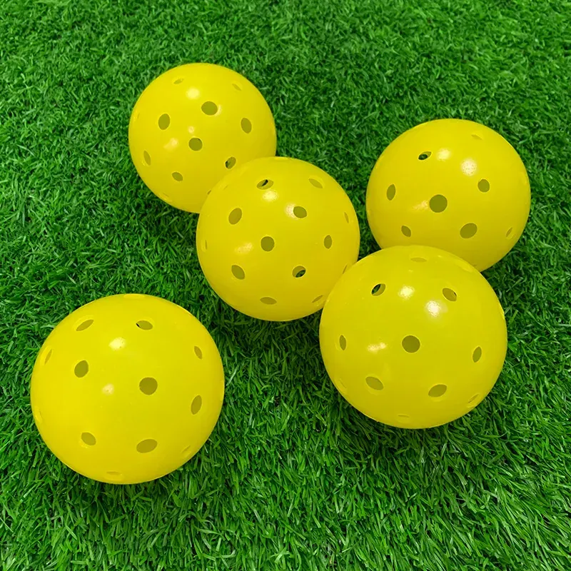 Yellow pickleballs on outdoor turf