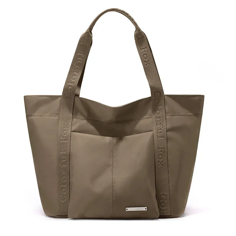 Khaki nylon tote bag with front slip pocket and short webbing handles with printed text, front view