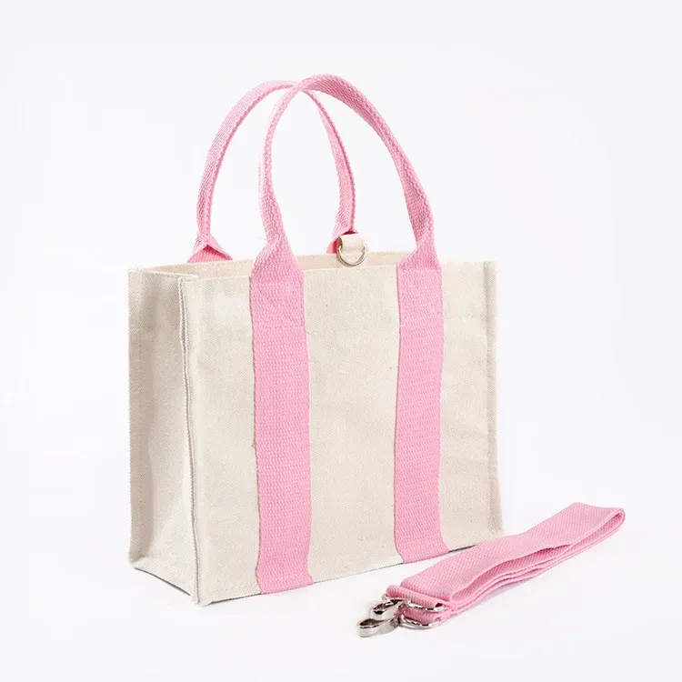 Cream mini canvas tote with pink webbing handles and a detachable pink shoulder strap with metal clips
