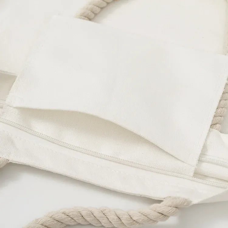 Interior close-up of ivory rope-handle tote showing inner patch pocket and zippered pocket