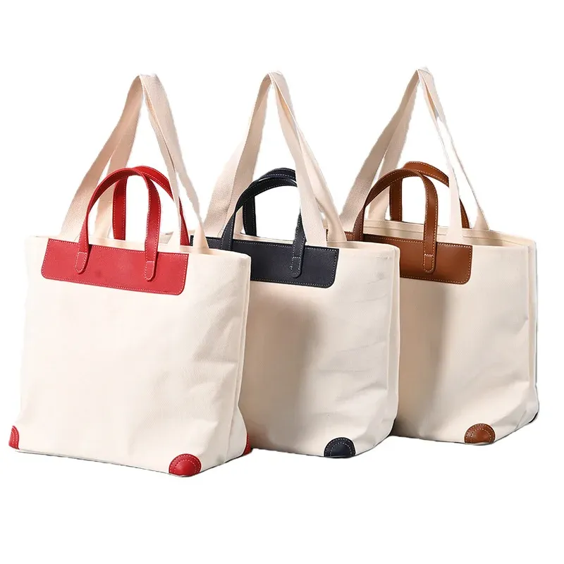 Three ivory 16oz canvas tote bags with red, black and brown leather-trim short handles and long webbing shoulder handles