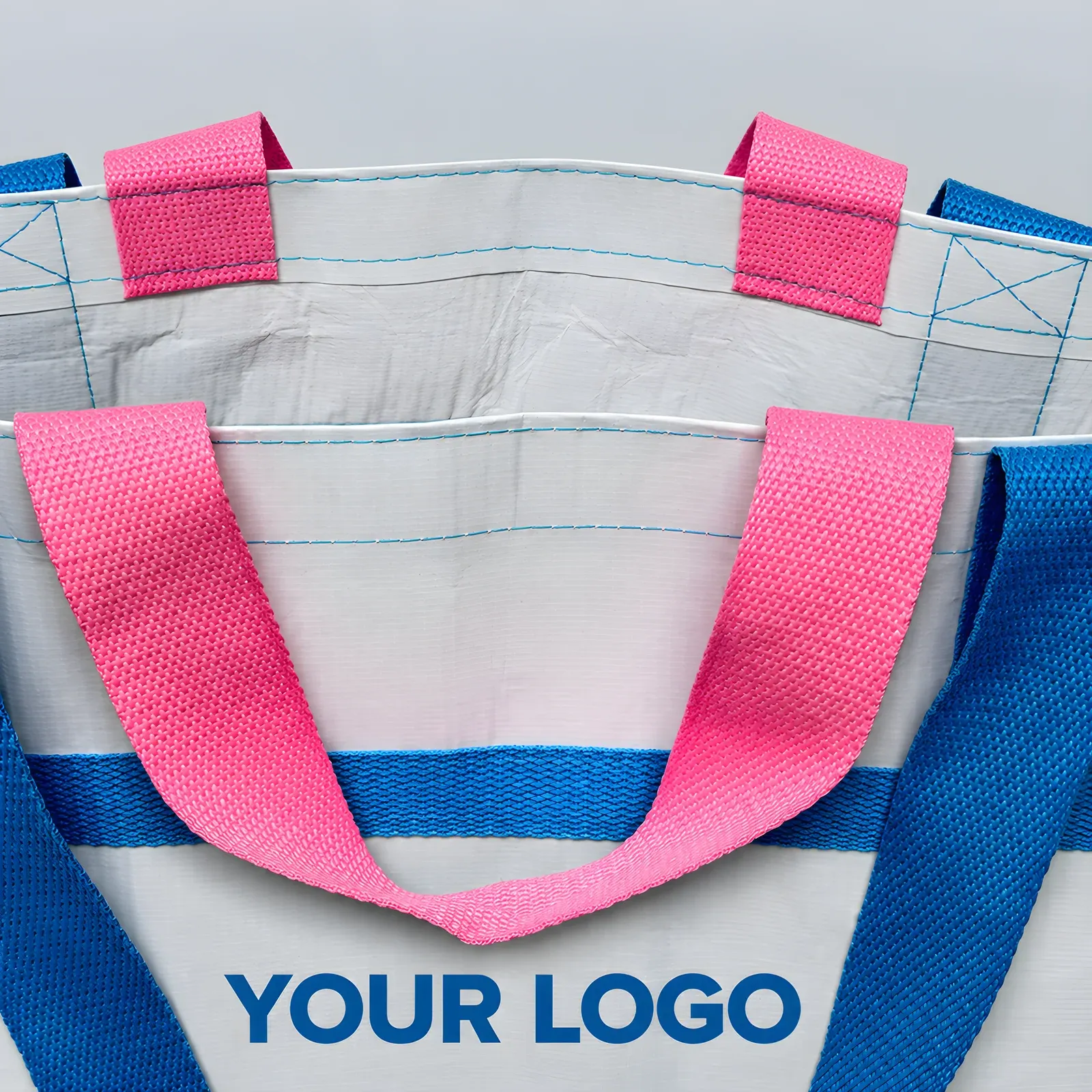 Close-up of pink and blue webbing handles and contrast trim stitching on the white RPET tote