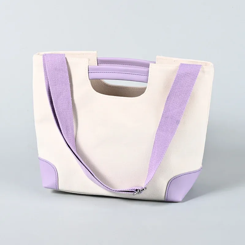 Cream canvas tote with purple trim, padded purple short handle and long purple shoulder strap with metal clasp
