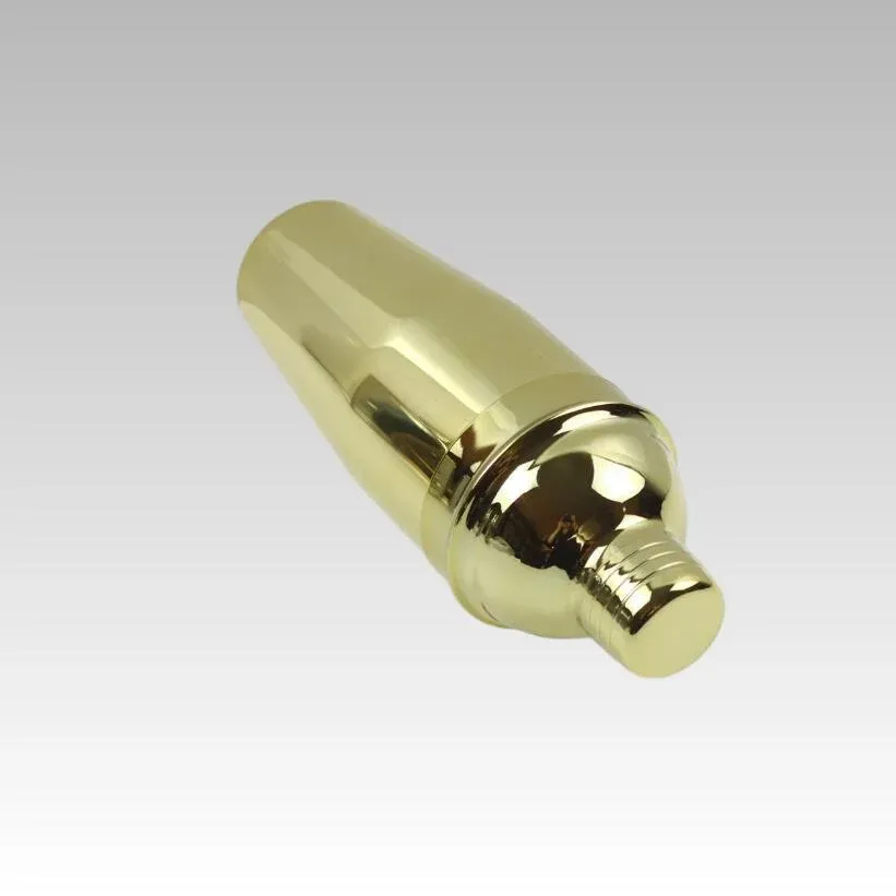 Gold-finish stainless steel cocktail shaker lying at an angle on a white background