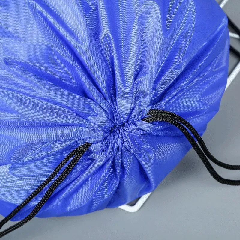 Close-up of the gathered cinch top of a blue heavy-duty drawstring backpack with black braided drawcords