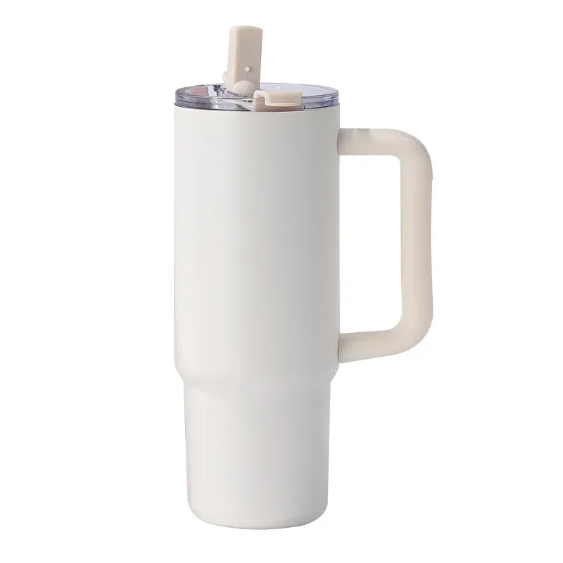 Cream white insulated tumbler with molded side handle, clear lid with cream straw tab, three-quarter view on white background