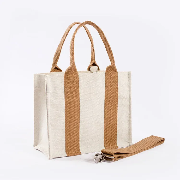 Cream mini canvas tote with tan webbing handles and a detachable tan shoulder strap with metal clips