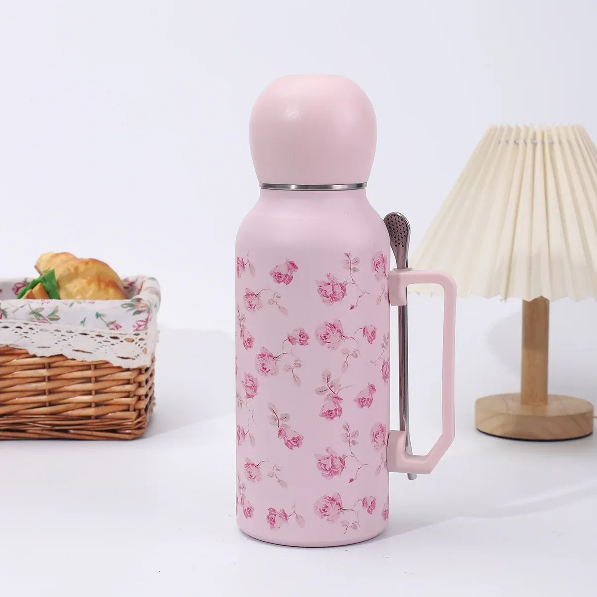 Pink rose floral 1300ml vacuum bottle with pink dome lid, side handle and metal filter-spoon straw, lifestyle view