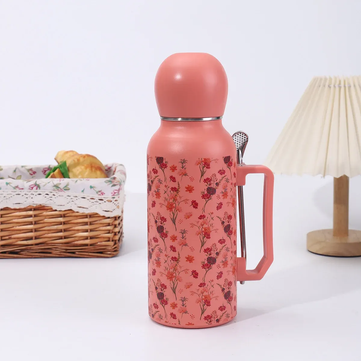 Coral pink ditsy floral 1300ml vacuum bottle with coral dome lid, side handle and metal filter-spoon straw, lifestyle view