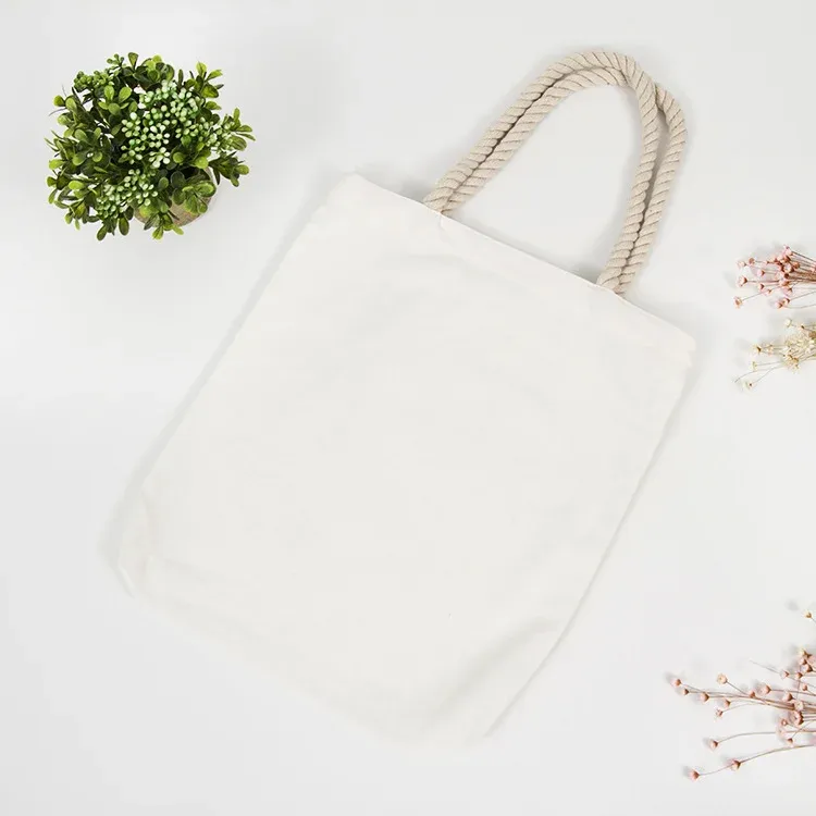 Flat lay of ivory rope-handle cotton tote bag on a white background