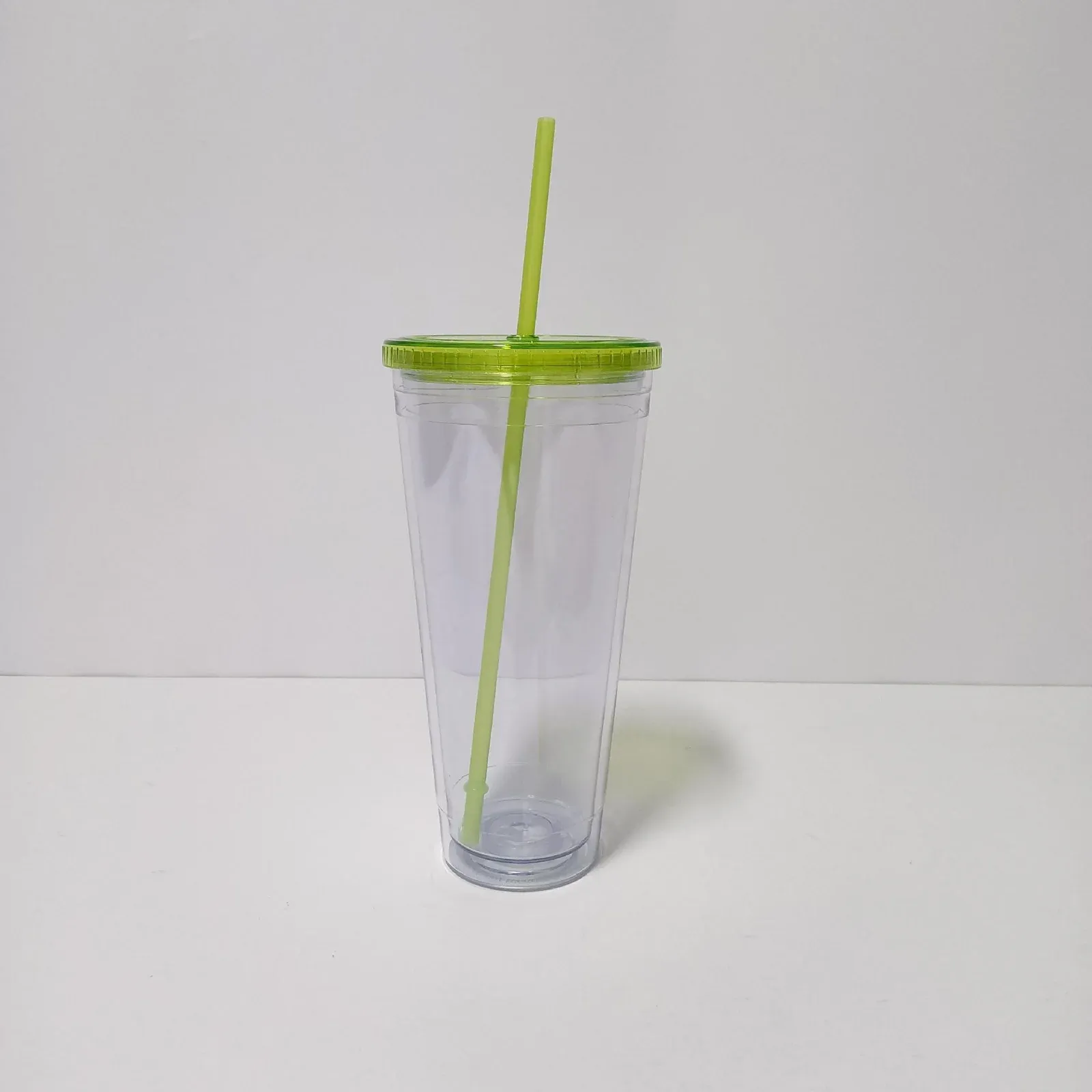 Clear double-wall plastic tumbler with translucent green lid and green straw, no handle