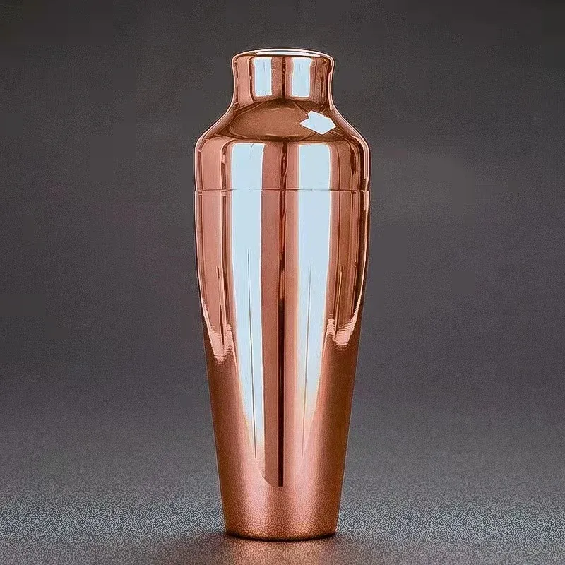 Glossy copper-finish stainless steel cocktail shaker on a grey background